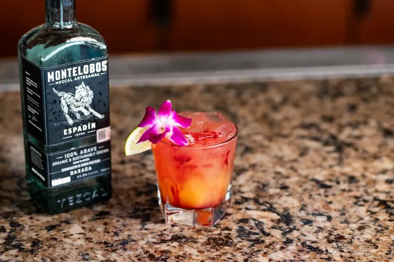 A Sea Dragon cocktail beside a bottle of Montelobos mezcal