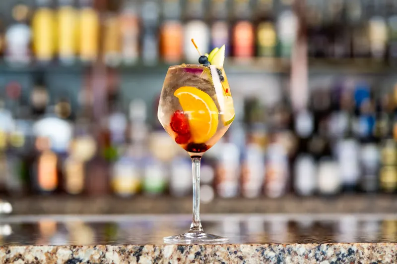 A fruit-garnished cocktail in a wine glass